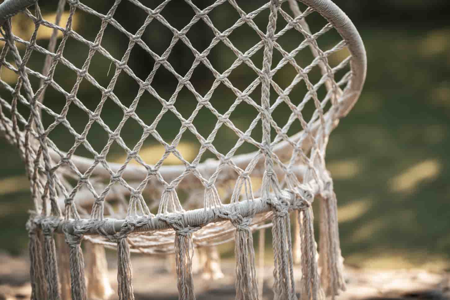An image of a cozy wicker chair hammock in the garden.