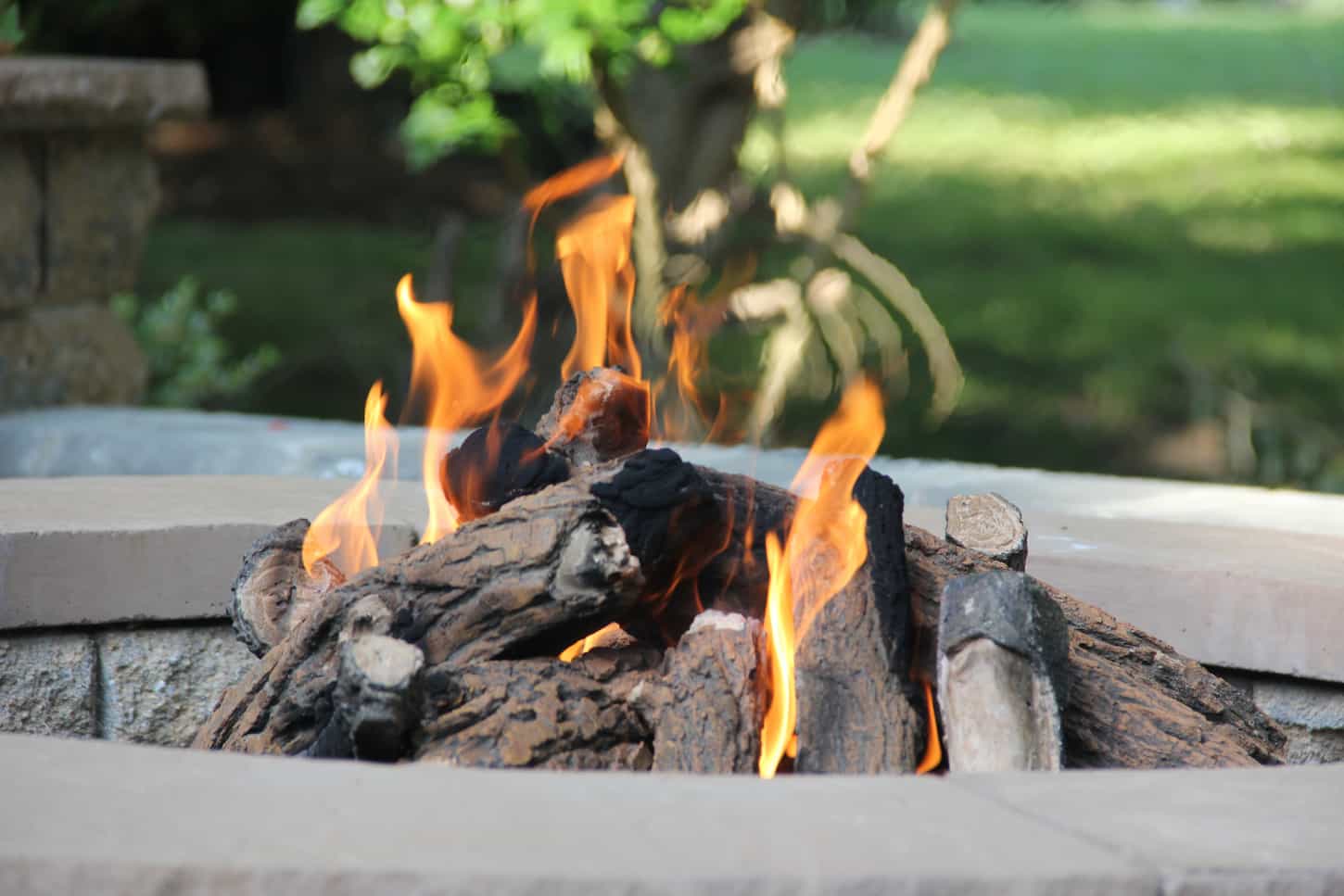 An image of Getting the fire ready with wooden logs in the fire pit for a fun summer gathering.