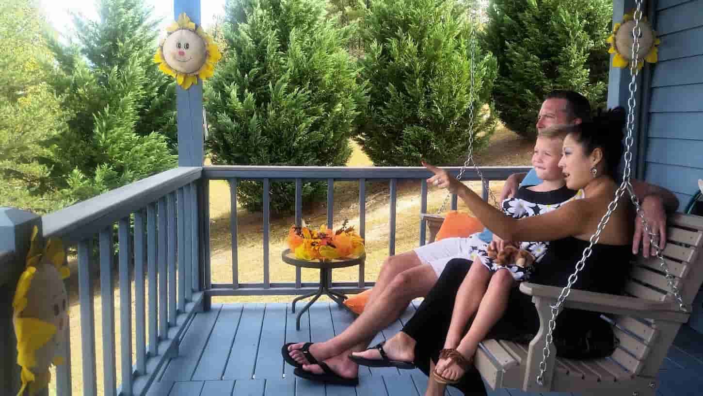 An image of a Happy family sitting on a porch swing enjoying quality time together on vacation.