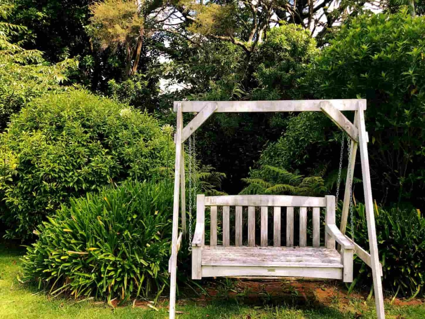 An image of a Wooden bench swing in the garden.