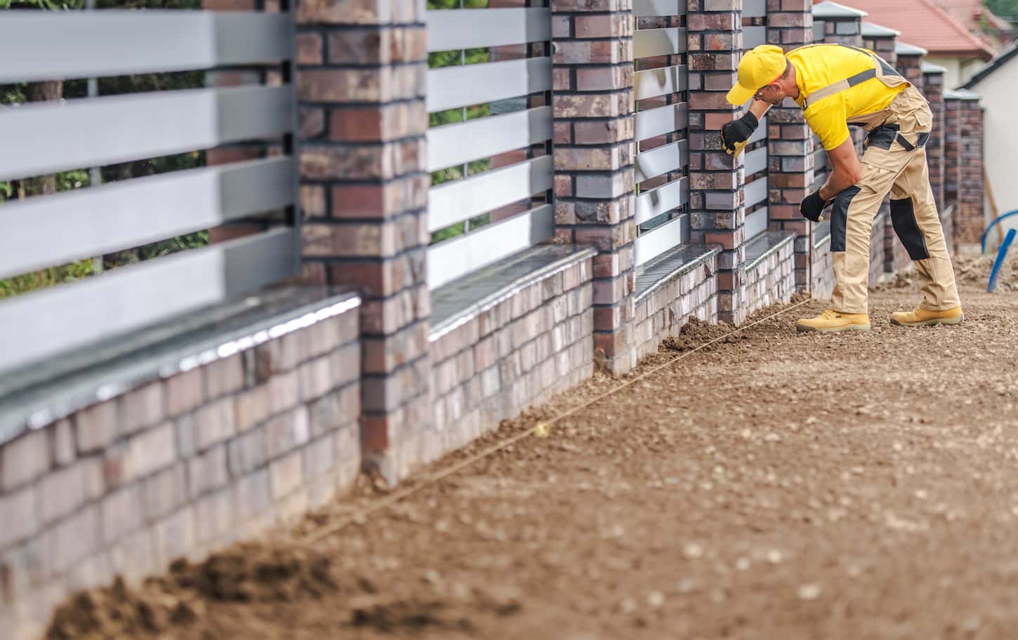 An image of a Residential Decorative Fence Building by a Professional Caucasian Worker. Finishing Fence Assembly.