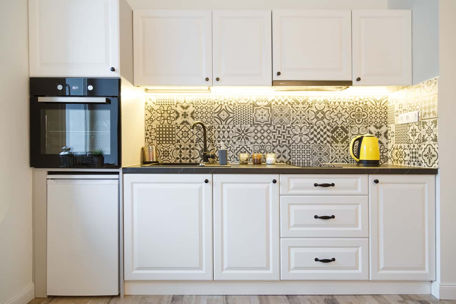 An image of a Beautiful home kitchen with white cabinets and backlight.