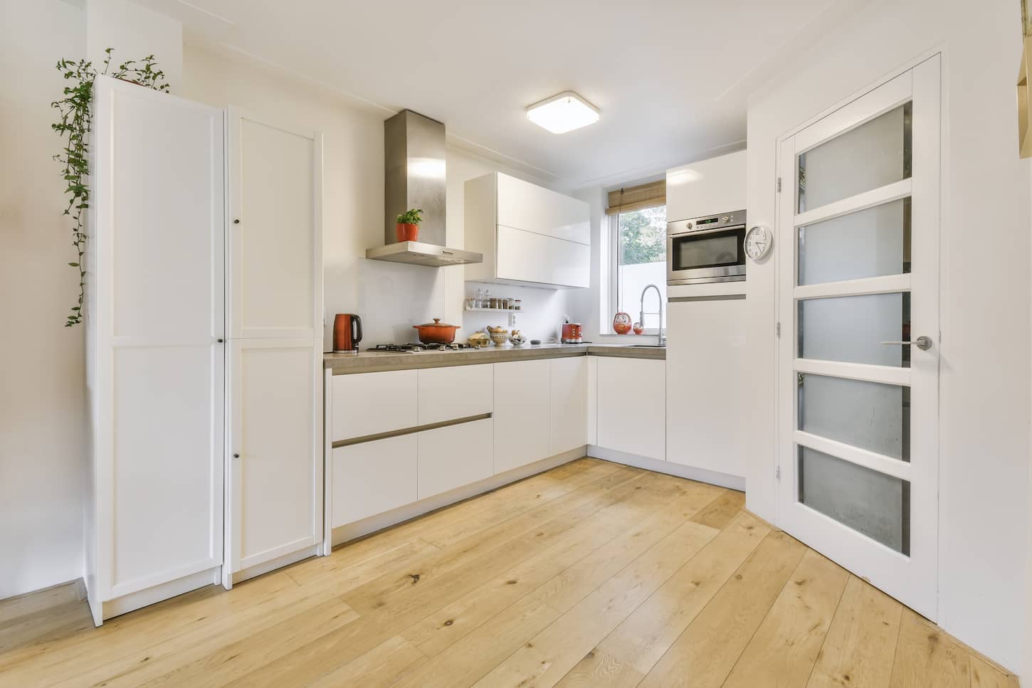 An image of a Cozy daylight kitchen with white cabinets and hardwood floors.